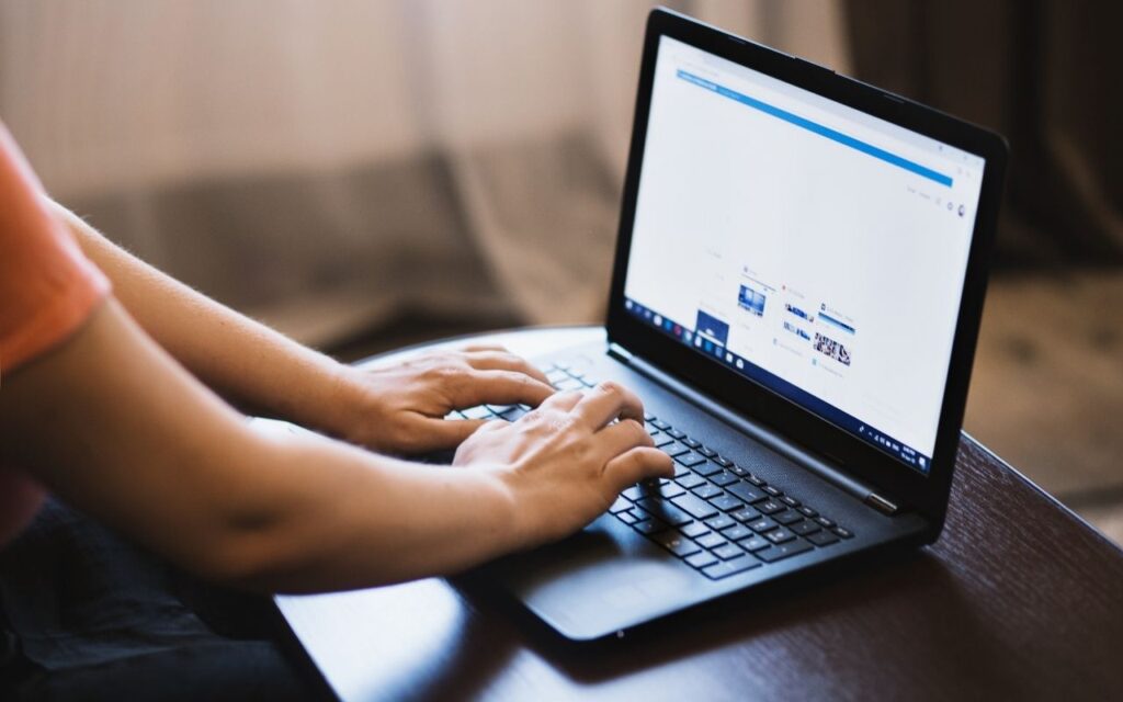Person searching the internet on a laptop computer.