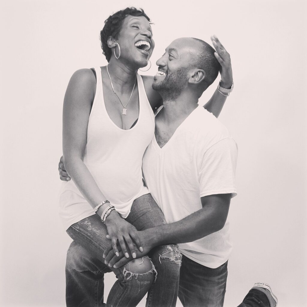 An African American couple, her sitting on his knee, laughing and smiling. Planning for retirement