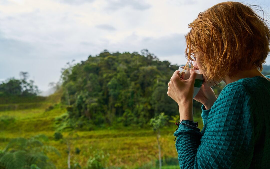 Woman drinking coffee and looking off into the distance.