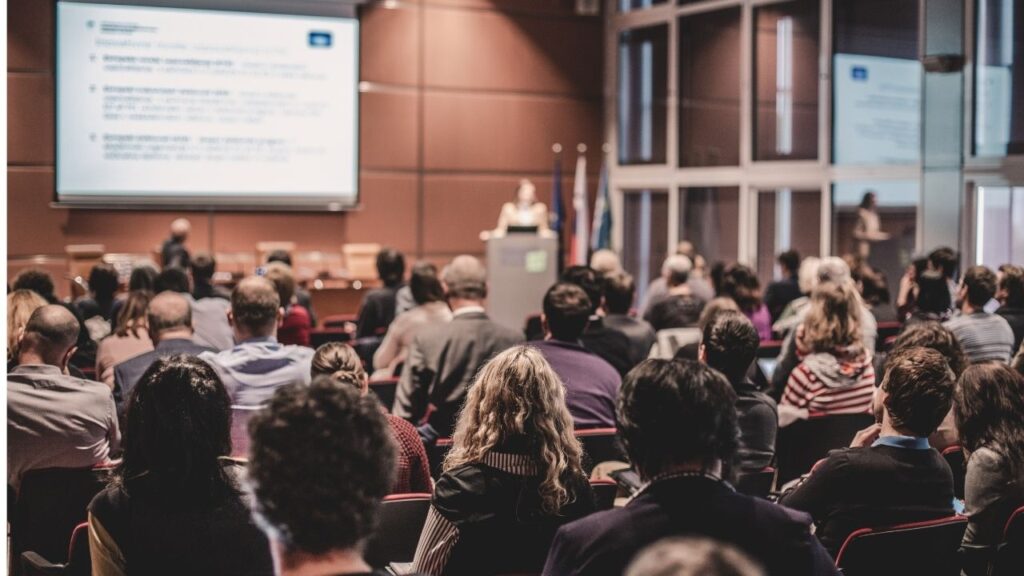 A room full of people listening to a lecture.